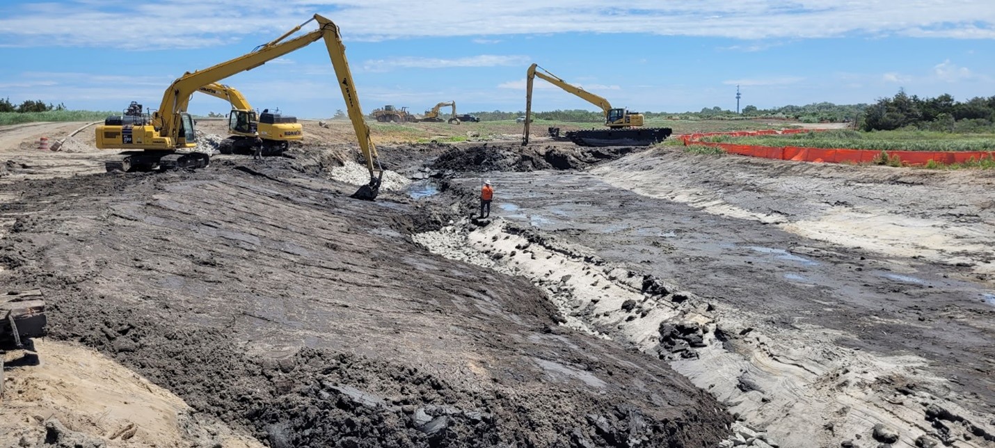 Excavated wetland material placed over stone near the mouth of Pond Creek – June 2024